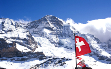 Besneeuwde bergen met Zwitserse vlag.